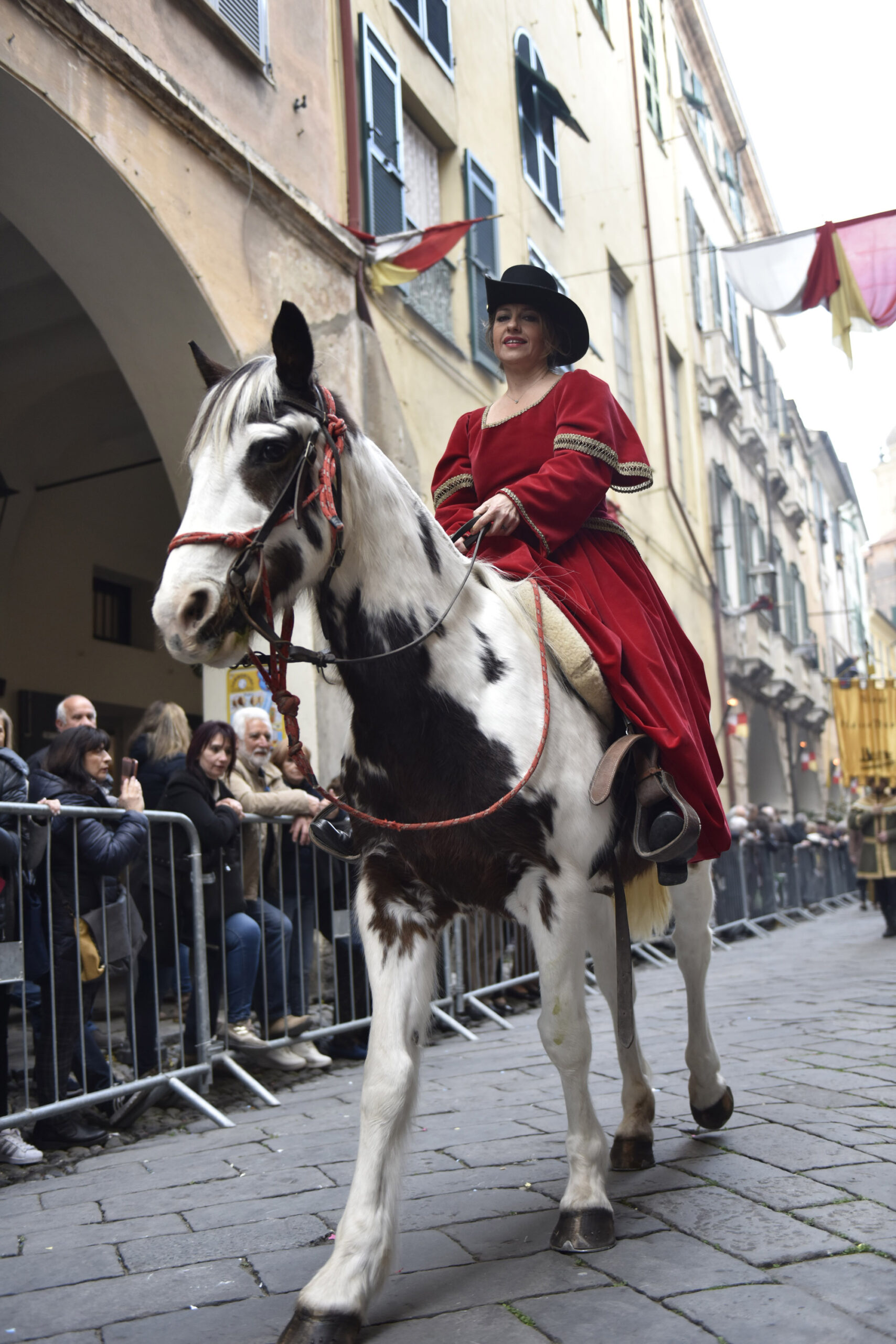 Una donna a cavallo vestita con abiti storici sfila durante il corteo storico di Taggia